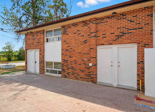 A red brick house with a white door and windows.